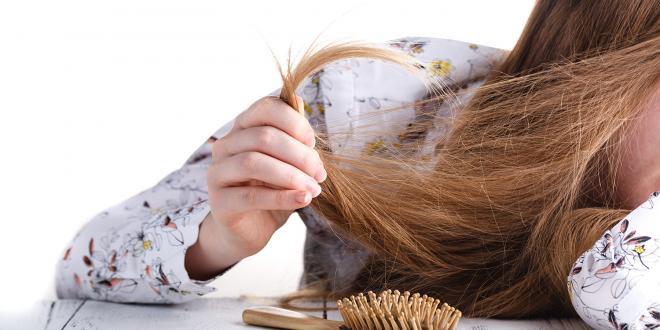 a young woman struggling with tangled hair and split ends